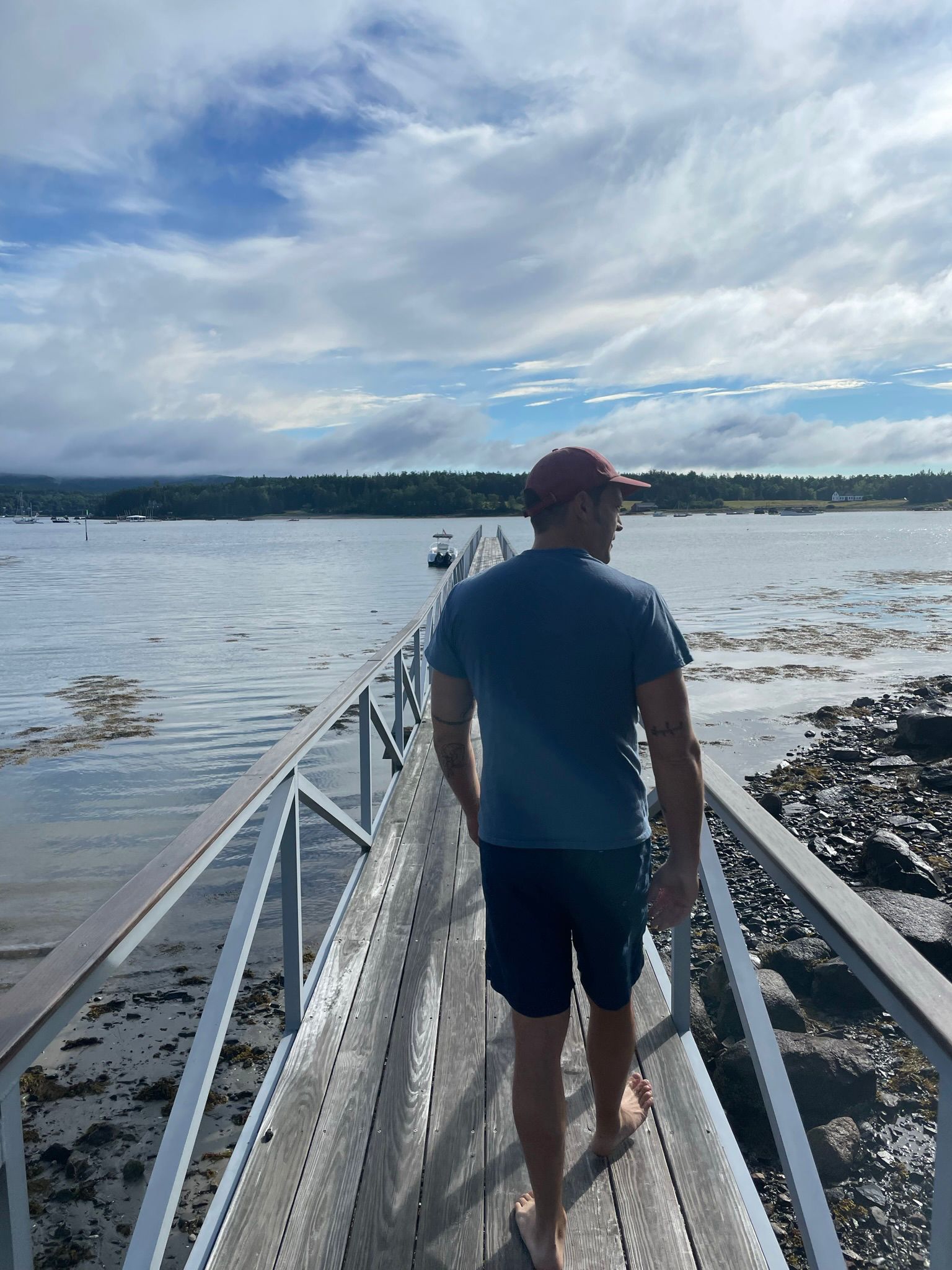 Josh Flash walking along a dock toward the water, seen from behind